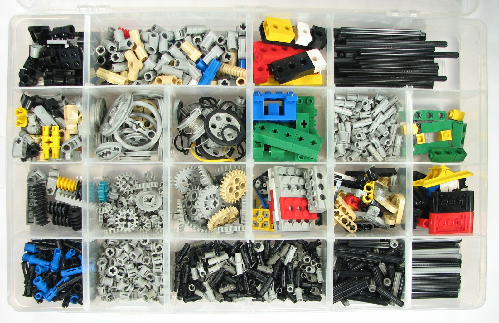 A clear plastic organiser with a dozen compartments, each holding a different kind of LEGO Technic part: gears, pins, axles, beams, wheels and connectors